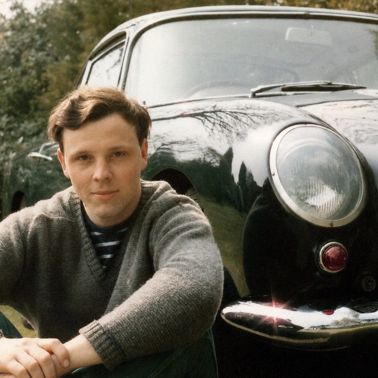 Mike sitting beside the front of his Aston Martin DB4 in 1984